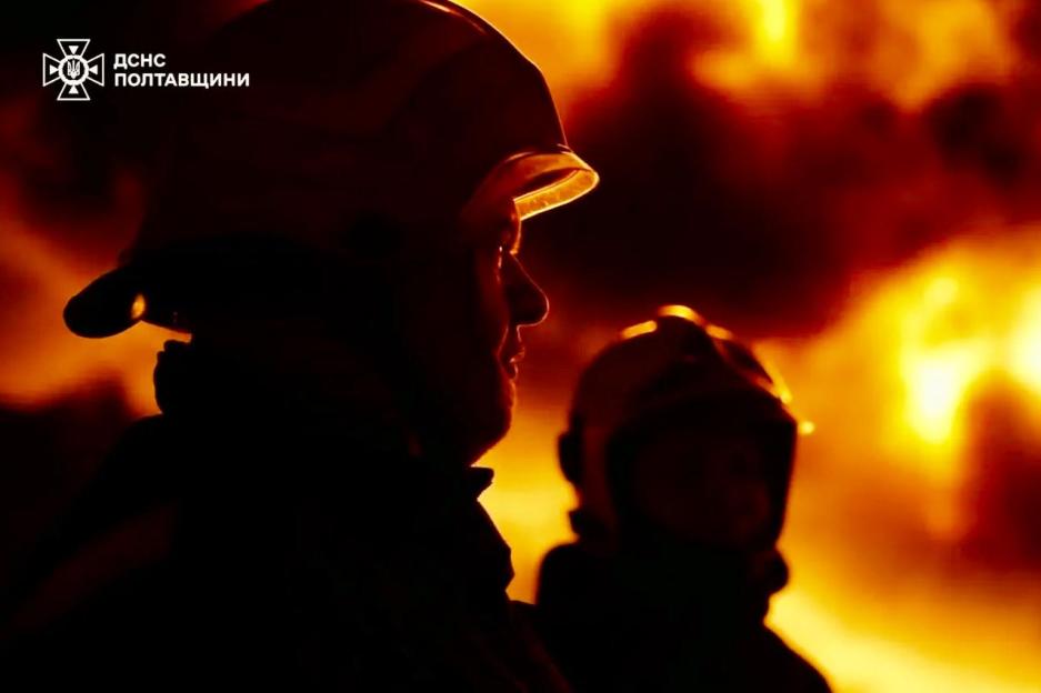 Silhouettes of two firefighters against a fiery background.