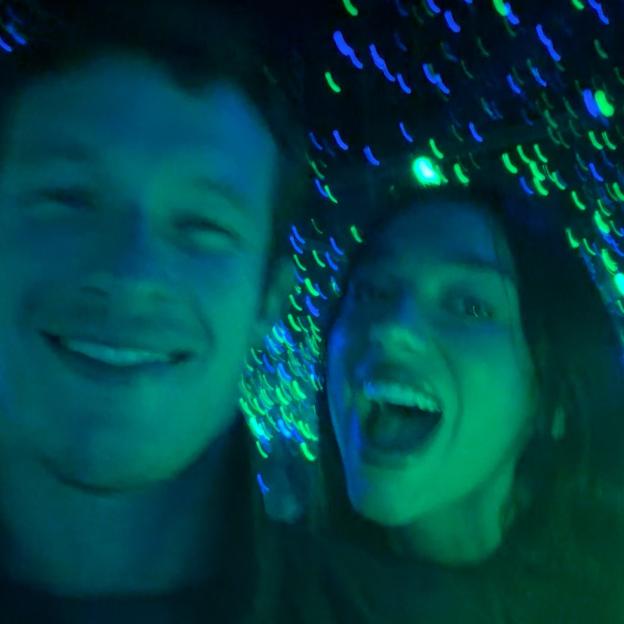 Dua Lipa and Callum Turner in Copenhagen with neon lights.