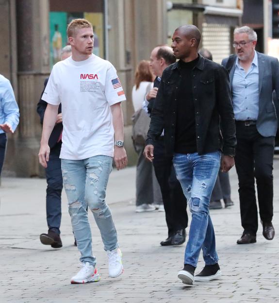 Manchester City players Kevin De Bruyne and Fernandinho walking.