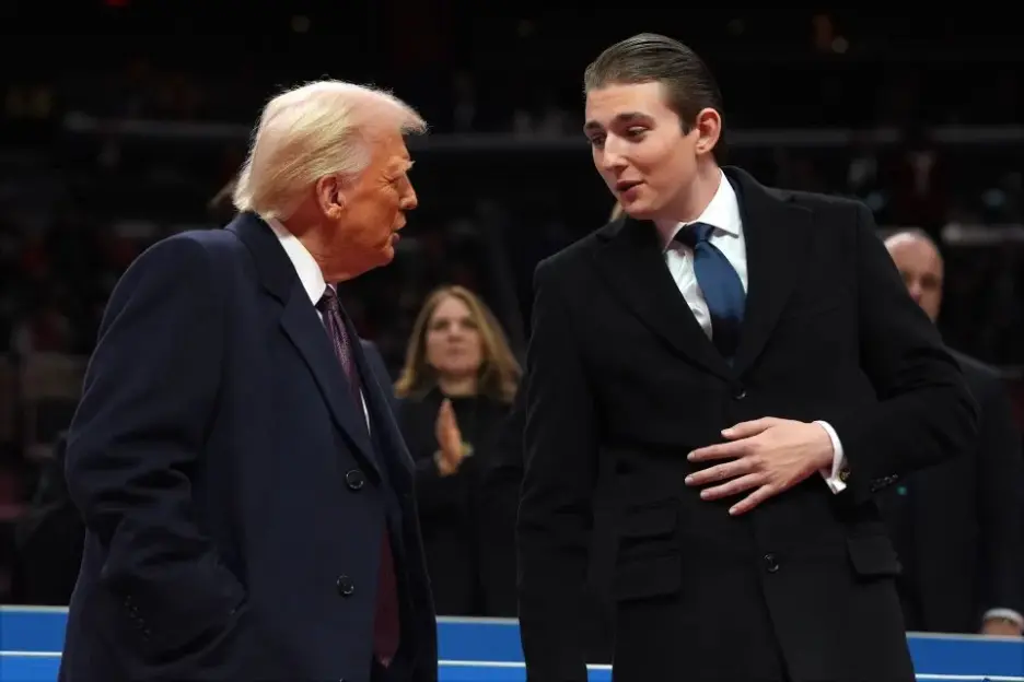 Donald Trump talking to his son, Barron Trump, at a public event.