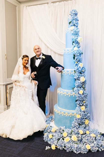 Tyson and his bride pose with their giant blue wedding cake.