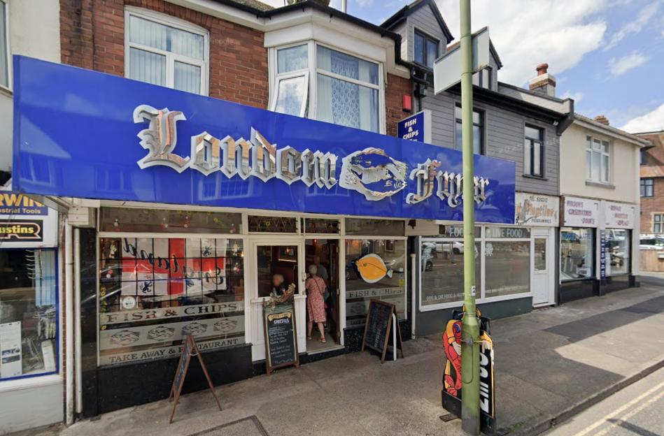 The London Fryer fish and chips restaurant with two people walking out the door.