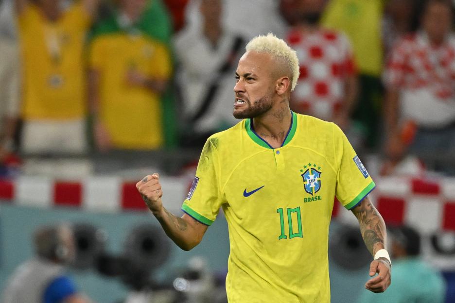Neymar of Brazil wearing a yellow jersey with the number 10, clenches his fist and shouts.