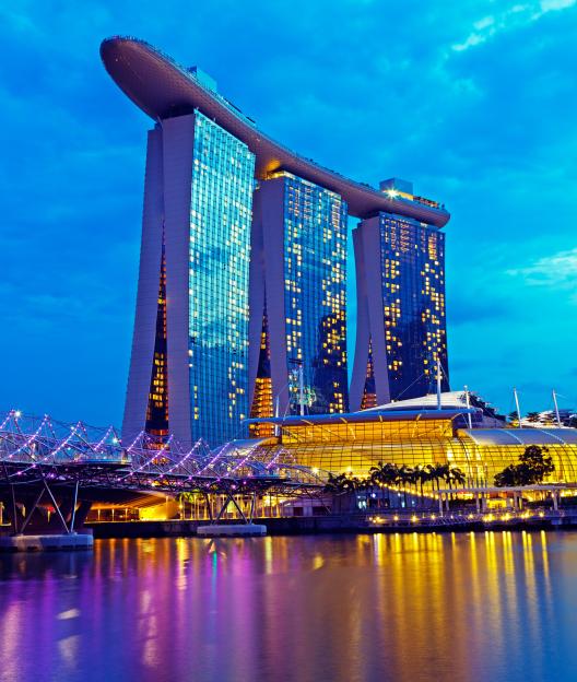 The illuminated Marina Bay Sands complex in Singapore at dusk.