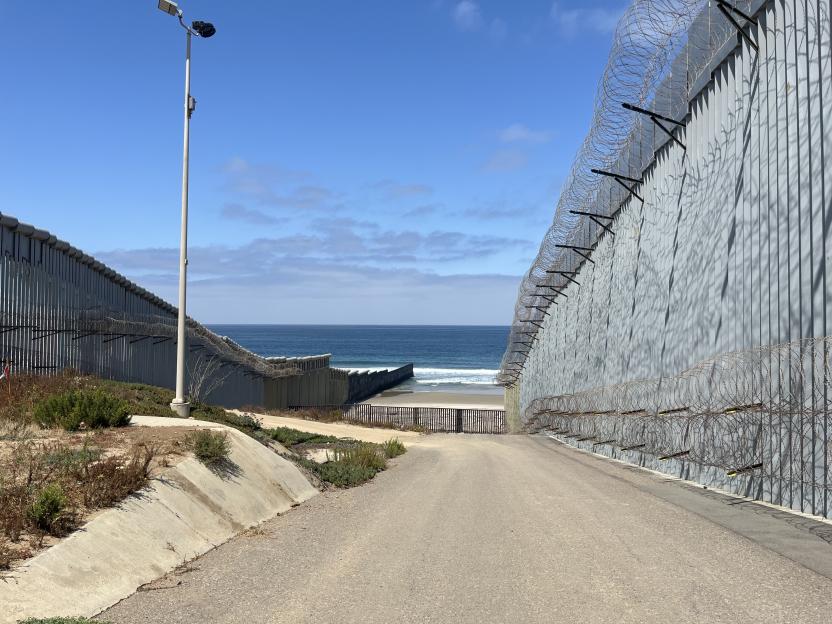 The US-Mexico border wall extending into the Pacific Ocean.
