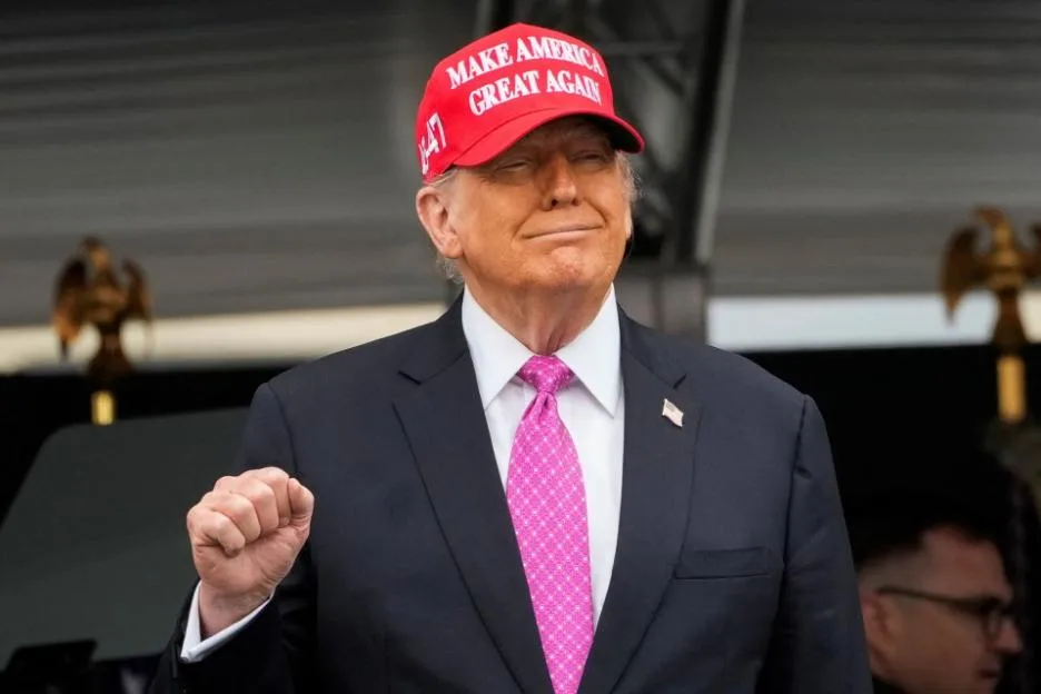 Donald Trump in a red "Make America Great Again" hat and a pink tie, at the West Point Military Academy commencement.