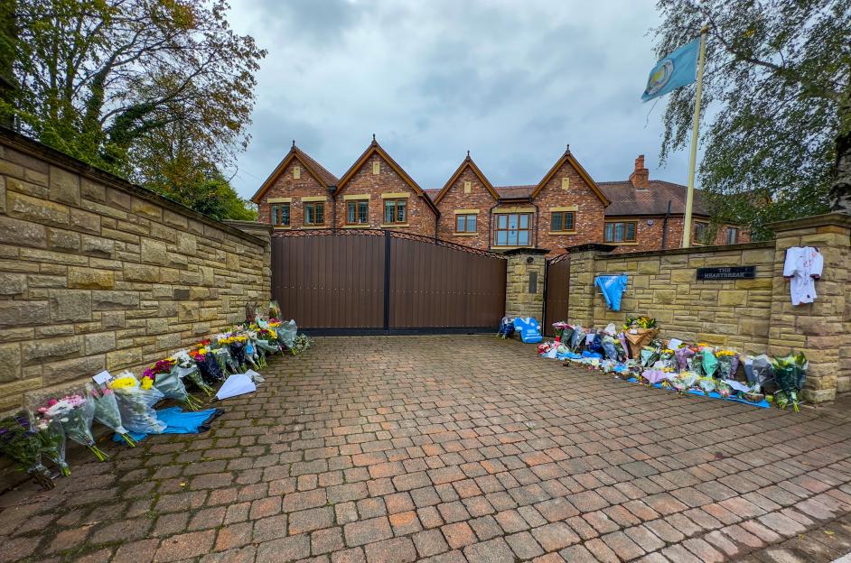 Tributes of flowers and shirts line the stone wall outside Ricky Hatton's home.