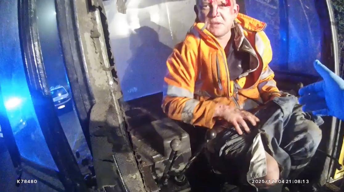 CCTV footage of Daniel Morgan, with blood on his head and hands, sitting in a bulldozer as a police vehicle approaches.