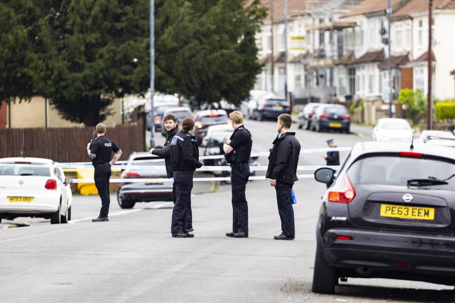 Police officers standing in a street cordoned off with tape due to a major incident in Speedwell, Bristol.