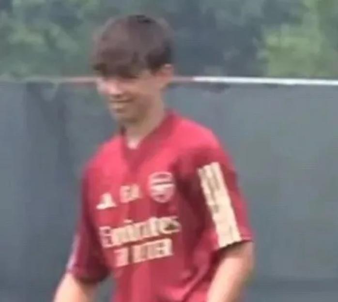 A boy wearing an Arsenal Football Club jersey.