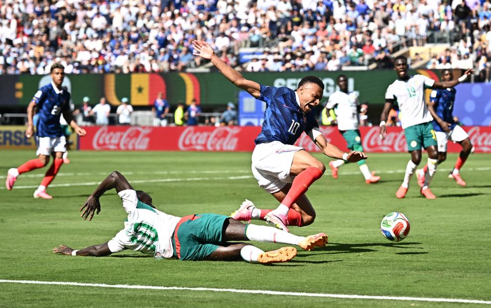 Senegal's Sadio Mane on the ground as France's Kylian Mbappe jumps over him in the penalty area during a FIFA World Cup soccer match.