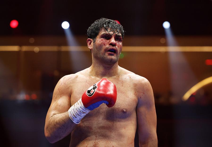 Filip Hrgovic with a bloodied face and body during a boxing match.