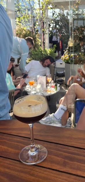 Jack Grealish asleep in a corner of a rooftop bar with drinks on a table nearby.