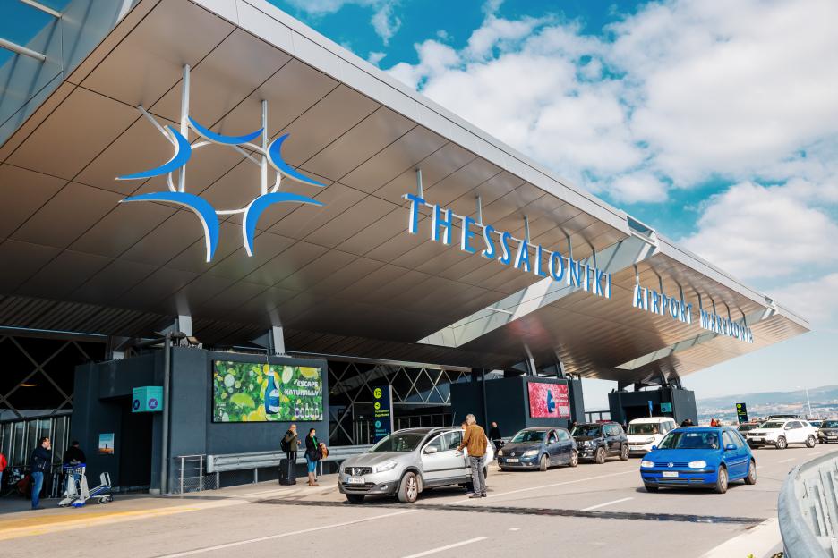 airport terminal of Thessaloniki Macedonia with a road busy with cars and hurrying passengers