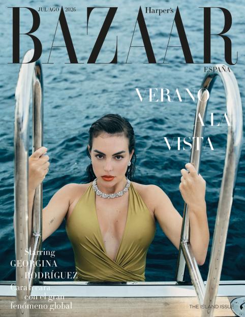 Georgina Rodríguez on the cover of Harper's Bazaar España, emerging from the water in a gold swimsuit and diamond necklace.