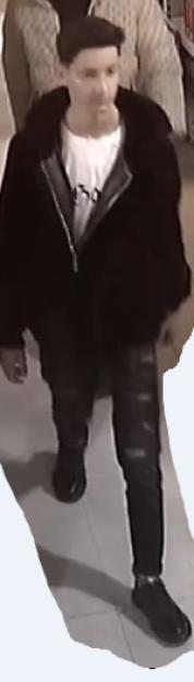 A young man wearing a black jacket, white t-shirt, and dark pants.