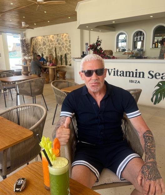 Wayne Lineker giving a thumbs up at a cafe in Ibiza.