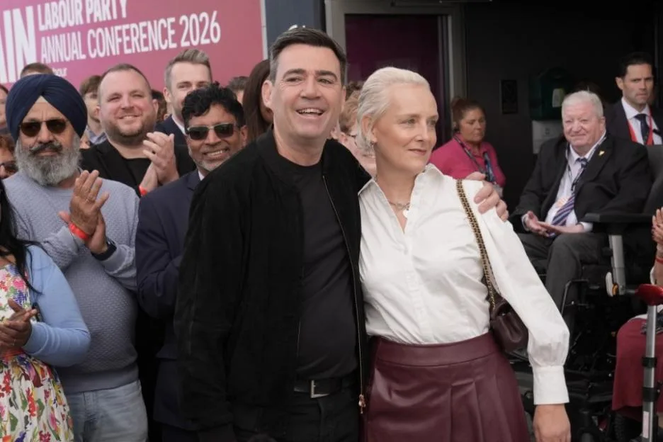 Andy Burnham and a woman standing in front of a crowd, with a banner for the "Labour Party Annual Conference 2026" visible in the background.