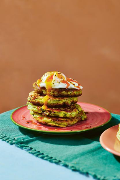 Stack of protein-rich pea pancakes topped with a poached egg and hot sauce.