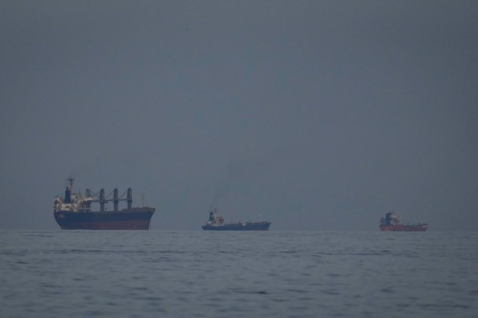 Three oil tankers and ships in a line on the Strait of Hormuz.