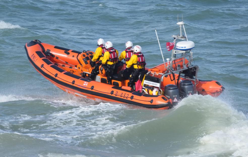RNLI boat with crew on choppy sea during a search operation.