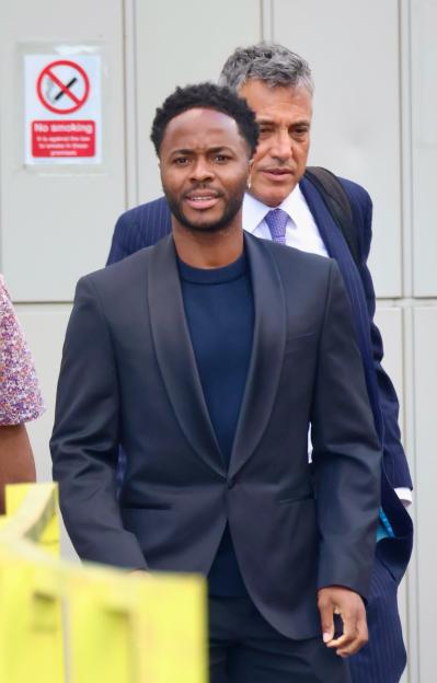 Raheem Sterling leaving Basingstoke Magistrates' Court, followed by a man in a suit.
