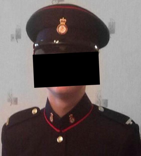 A person in a black Coldstream Guards uniform with a white belt and gold buttons.