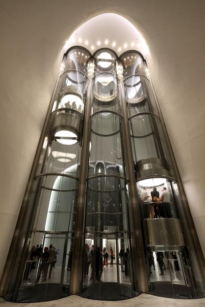 People ride the tube-like glass elevators at the Lucas Museum of Narrative Art.