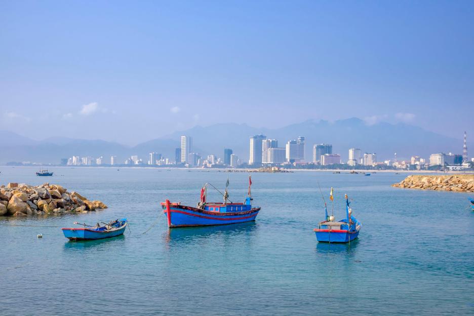 Nha Trang Bay with colorful boats and hotels lining the coast.