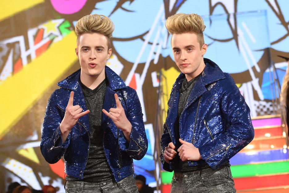 Twin pop act Jedward, in matching blue sequined jackets, posing as Celebrity Big Brother contestants.