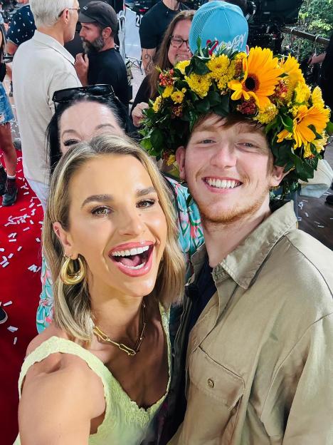Vogue Williams and Angry Ginge smiling, with Ginge wearing a flower crown.