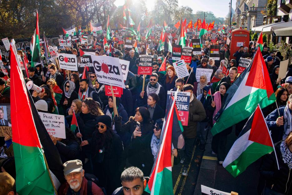 Palestine supporters march to Westminster, holding Palestinian flags and signs advocating for "Free Palestine" and an end to the "Gaza massacre."