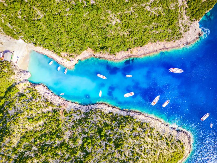 Aerial drone view of Porto Vromi Beach in Zakynthos, Greece, with boats in the turquoise water.