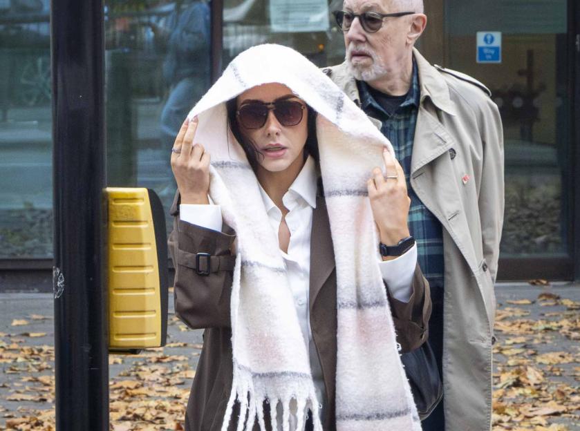 Probation Officer Bethany Dent-Reynolds covering her head with a scarf while leaving Westminster Magistrates' Court after being charged with misconduct.