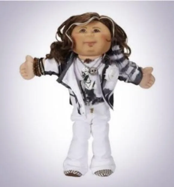 A Cabbage Patch doll dressed in a white and black rock star outfit with brown hair and white streaks.