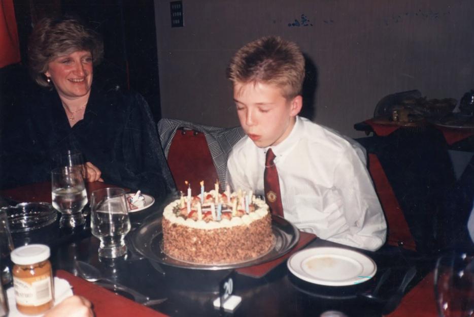 David Beckham celebrating his 51st birthday with a chocolate cake lit with candles.
