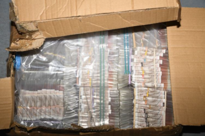 A cardboard box filled with hundreds of packages of cocaine wrapped in clear plastic.