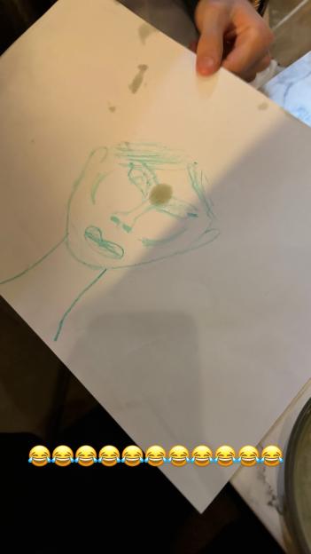 A light blue sketch of a human face on a white sheet of paper.