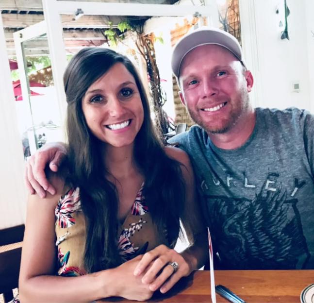 A smiling man and woman sit together at a table.