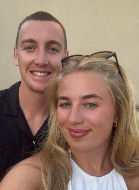 A smiling man and woman looking at the camera.