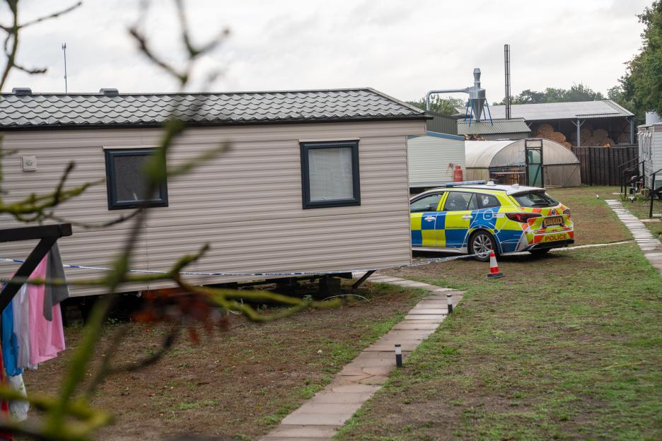 Police cordon around a mobile home on a seasonal farm workers' site.