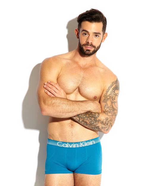Charlie King modeling blue Calvin Klein underwear.