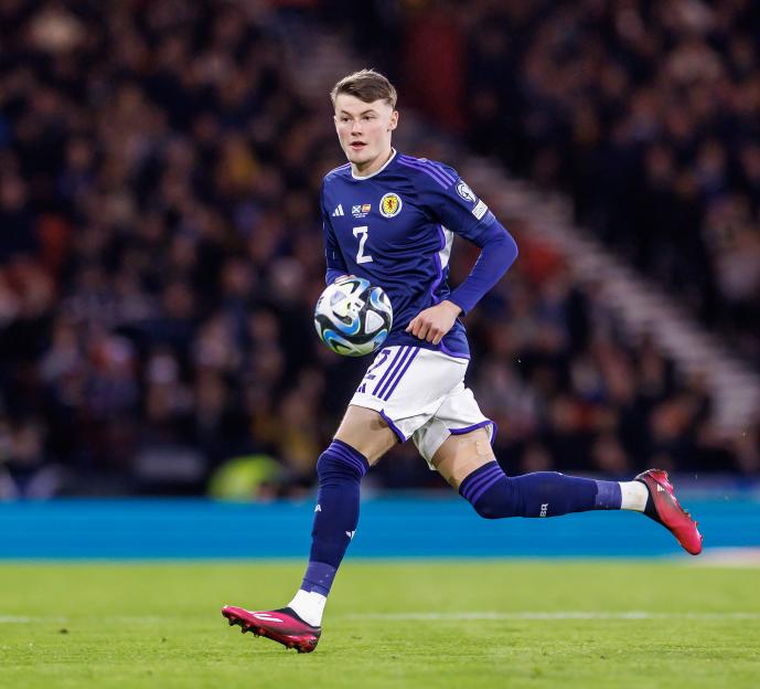 Nathan Patterson holding a soccer ball on a soccer field during a European Championship qualifier.