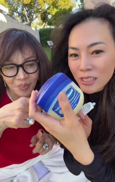 Two women looking at a container of Vaseline.