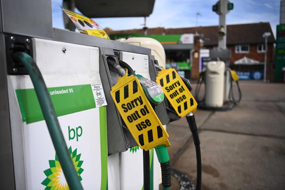 Gas pumps at a BP petrol station are tagged with yellow "Sorry out of use" signs due to a fuel shortage.
