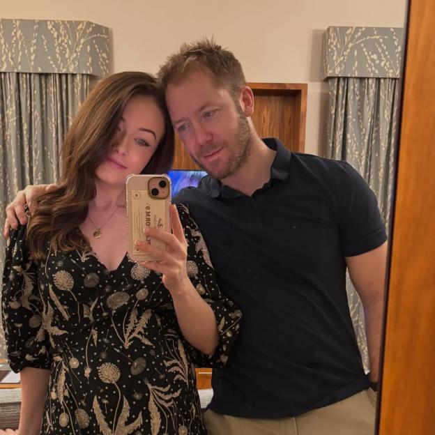 Jess Impiazzi cradles her 27-week bump while posing for a mirror selfie with a man.