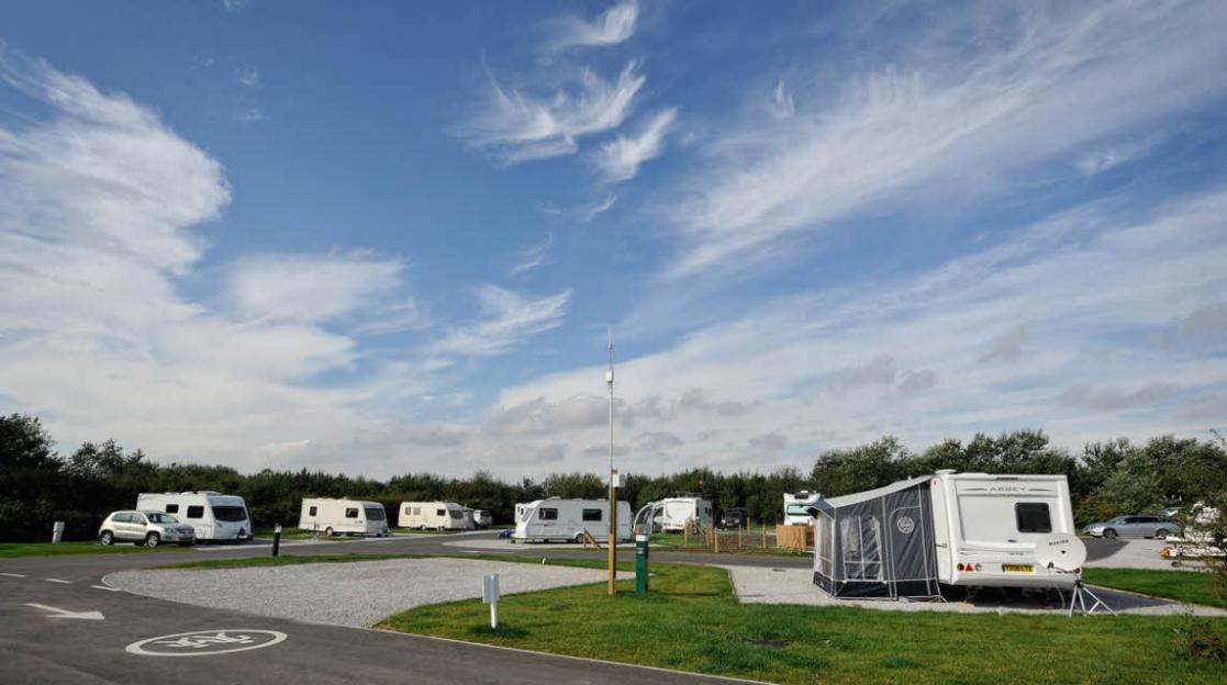 Bridlington Club Campsite with multiple caravans and a blue sky with wispy clouds.