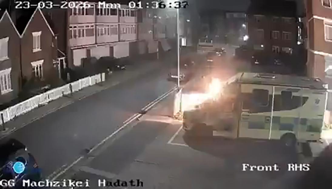 CCTV footage of an ambulance on fire in a residential street at night.