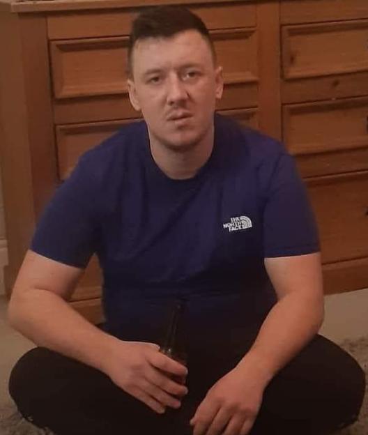 Ricky Harris, a missing man, sitting on the floor holding a bottle.