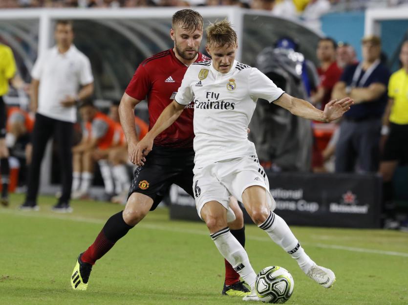 Real Madrid's Martin Odegaard controlling the ball in front of Manchester United's Luke Shaw.